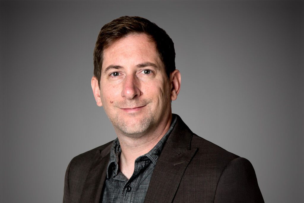 Headshot of Doug Snider in front of a gray background.