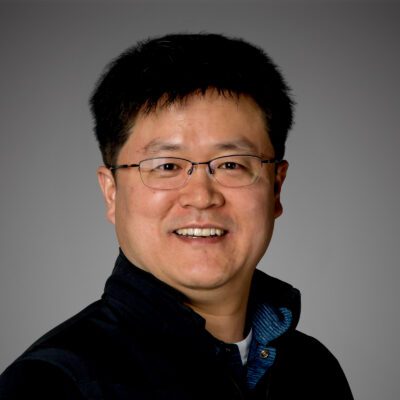Headshot of Euisang Lee in front of gray background.