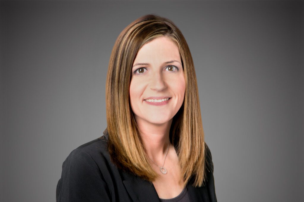 Headshot of Holly Rudnick in front of a gray background.