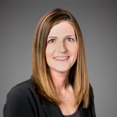 Headshot of Holly Rudnick in front of a gray background.