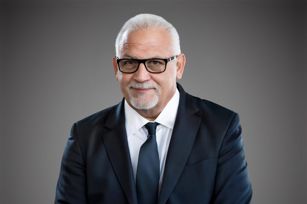 Headshot of James Jim Leopardo in front of a gray background.