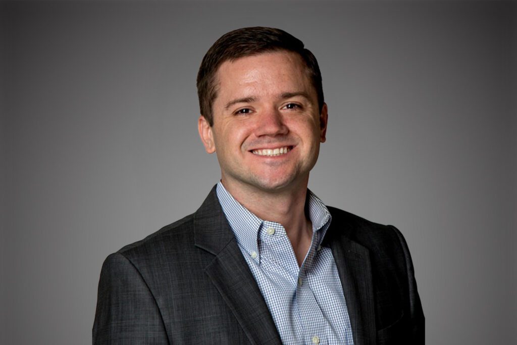 Headshot of Jeff Sauline in front of a gray background.