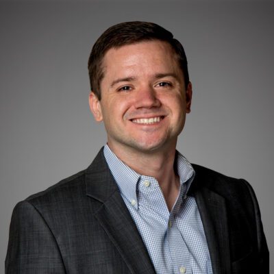 Headshot of Jeff Sauline in front of a gray background.