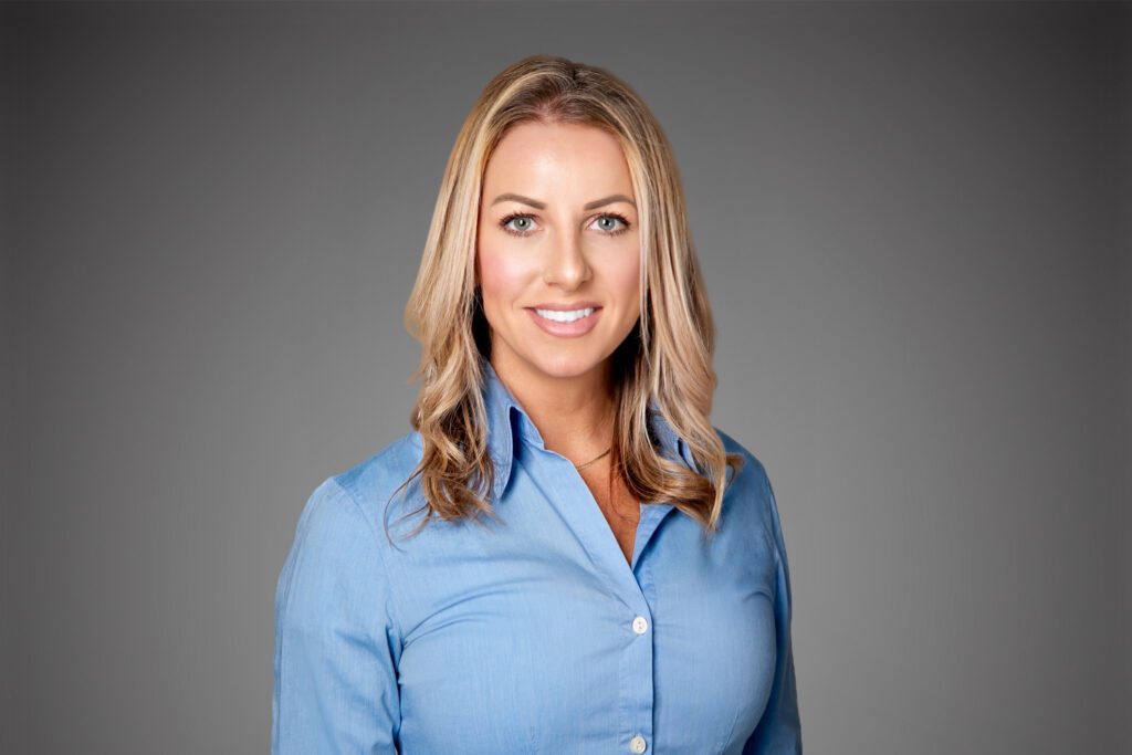 Headshot of Mallory Barnes in front of a gray background.