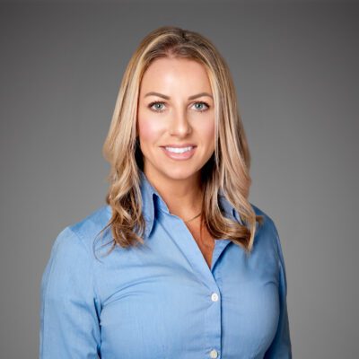 Headshot of Mallory Barnes in front of a gray background.