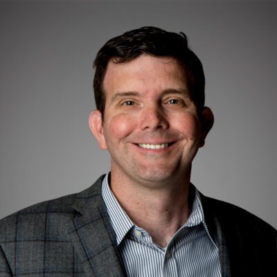 Headshot of Michael Mastin in front of a gray background.