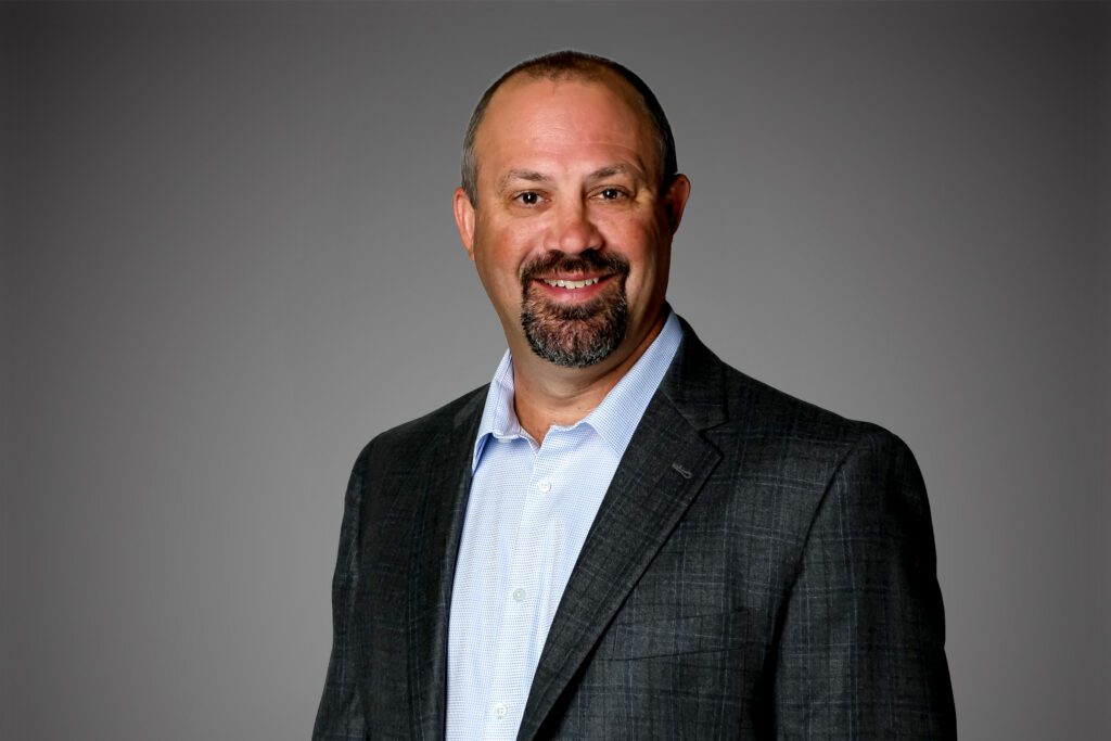 Headshot of Mike Haught in front of a gray background.