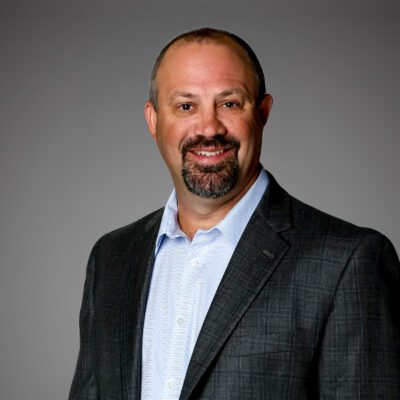Headshot of Mike Haught in front of a gray background.
