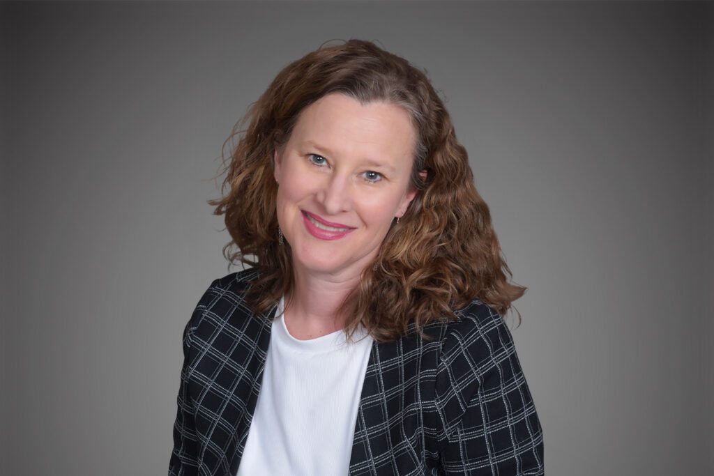 Headshot of Patty Lloyd in front of a gray background.