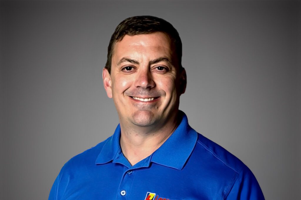 Headshot of Shawn Buehler in front of a gray background.