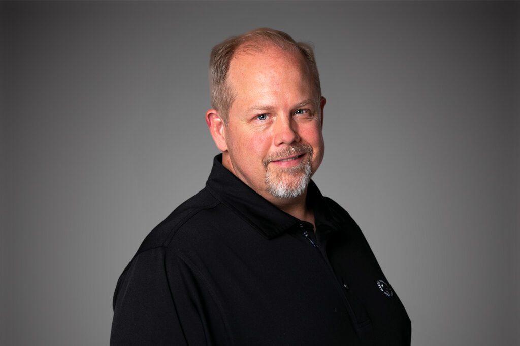 Headshot of Steve Cox in front of a gray background.