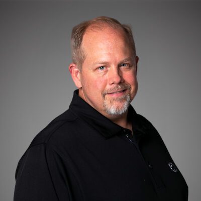 Headshot of Steve Cox in front of a gray background.